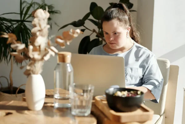 Eine Frau mit Beeinträchtigung arbeitet am Computer in einem Unternehmen. Genau das ist Inklusion, welche die Inklusis GmbH anstrebt