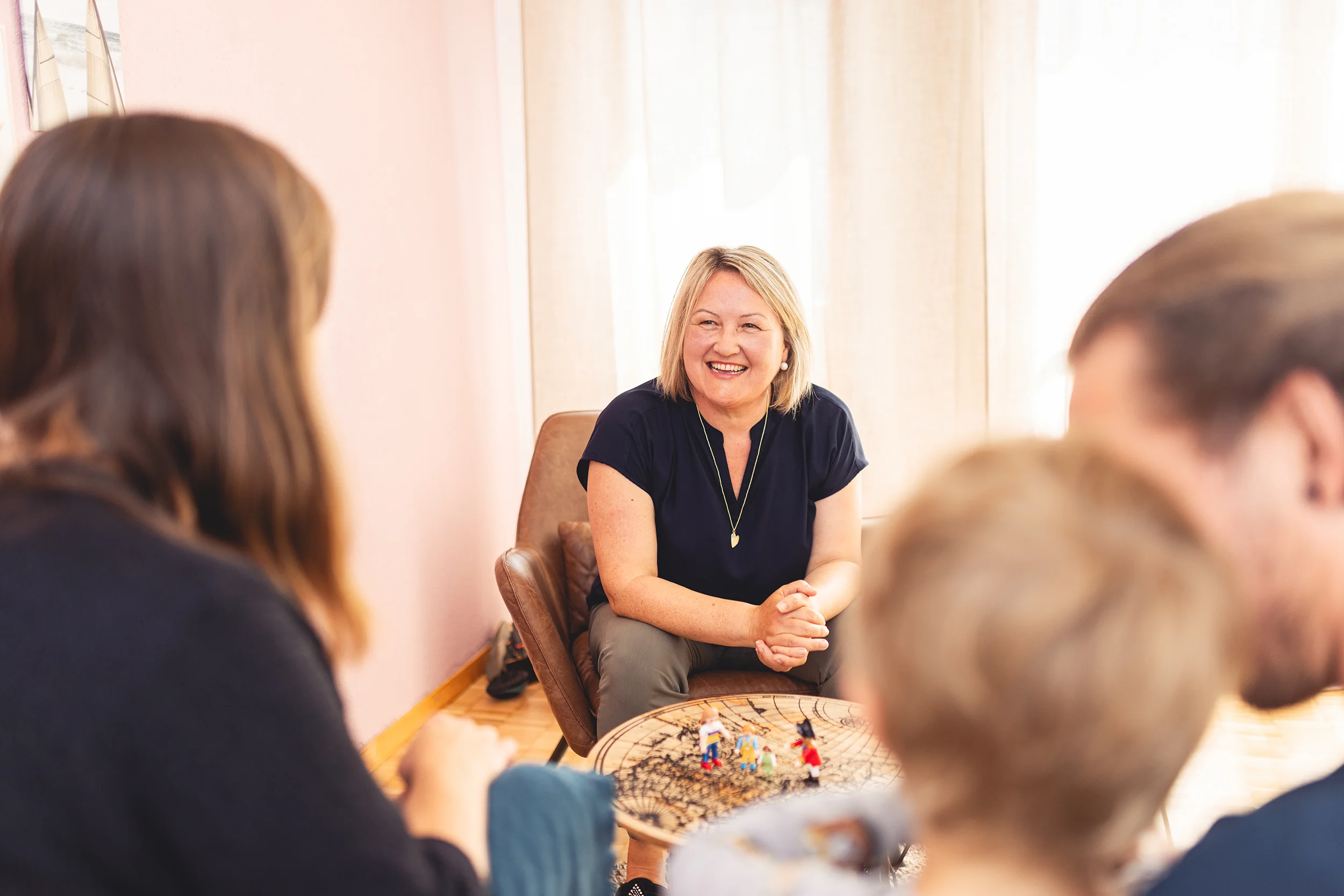 Thea Josi-Stauber von Vertrauenswelt zwischen einer Familie hindurch fotografiert, welche eine psychologische Beratung Elternberatung in Anspruch nimmt.